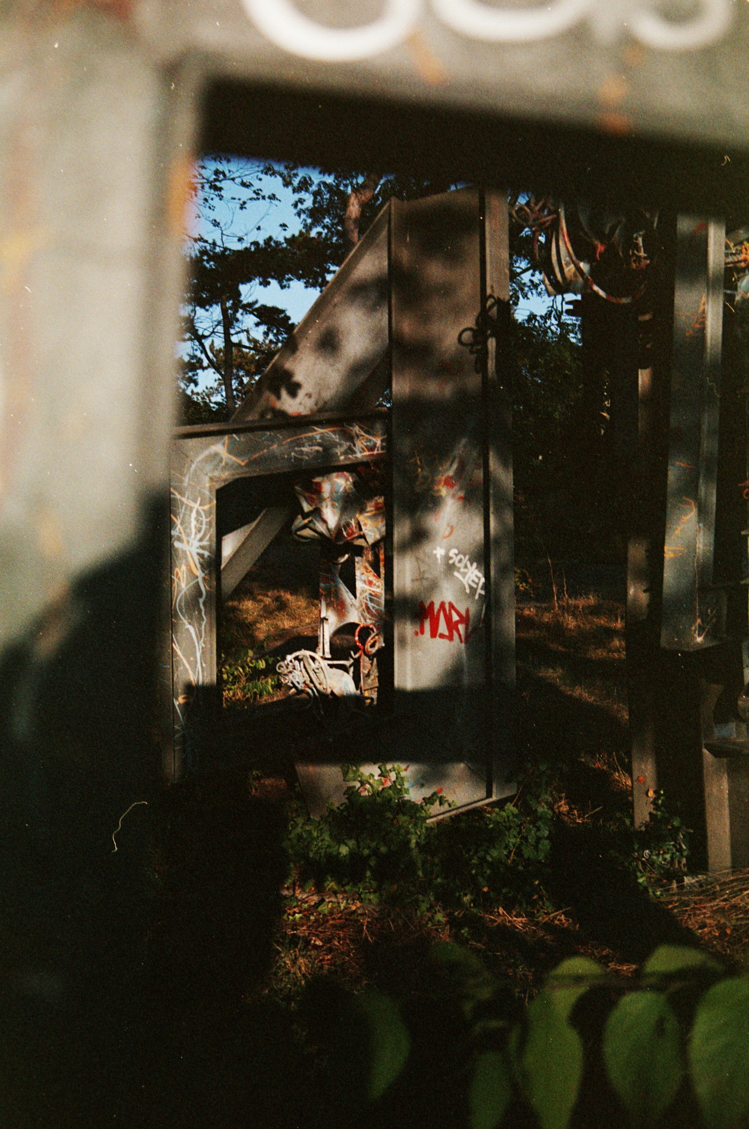 From the ground they arise, distorted beams of metal. Installed by some creative minds, seeking to catch the eye, of some park passers-by, that may find the contrast, pleasing to look at. Sun plays its part, helped by the trees, warming-up the cold steel, so it's not all gris.
