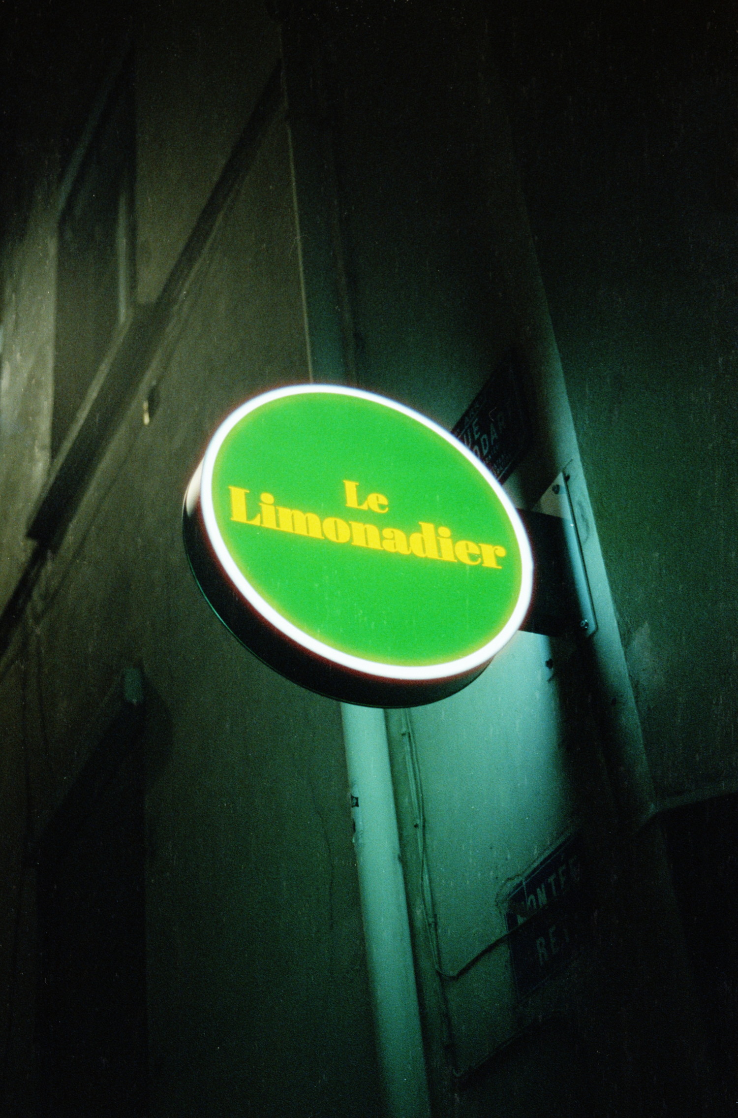 You may know I like green, so I had to take a shot at this beautiful sign I stumbled upon while taking the other night shots. It reads a simple "Le Limonadier" in a kind of vintage yellow font which nicely contrast with the intense green background. All wrapped in a simple circle shape with a white light outline spilling on the wall it is attached to.